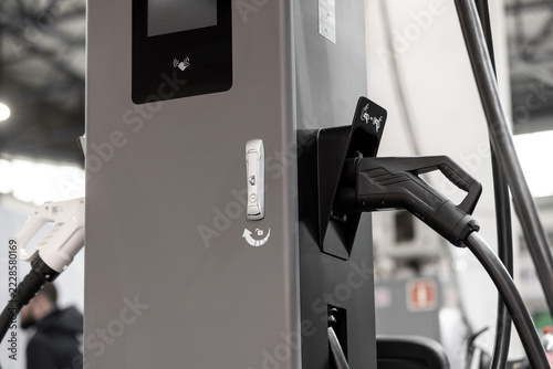 close-up of an electric vehicle charging plug in a charger station socket.