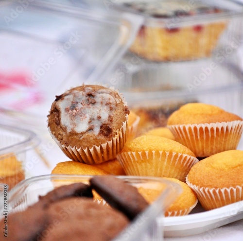 Assorted freshly baked muffins and cookies in clear plastic containers