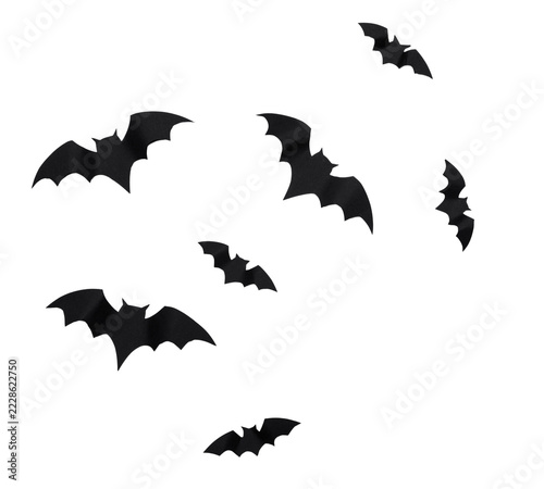 Black bat silhouettes flying across a white background at night