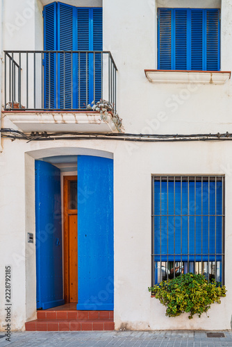 Traditional white building facade featuring vibrant blue wooden shutters