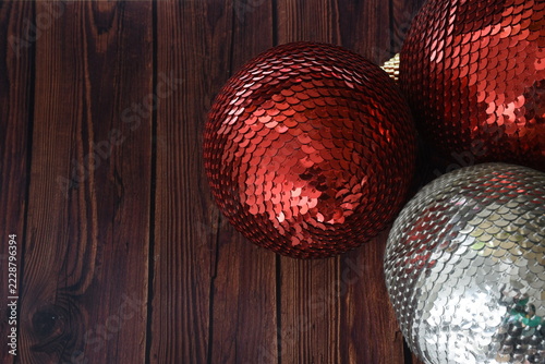 Top view of red and silver sequin Christmas baubles with sparkling glitter details, festive holiday decorations, elegant seasonal background, and shimmering metallic textures.