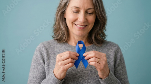 Mature Woman Holds Blue Awareness Ribbon for Health Charity Support and Hope
