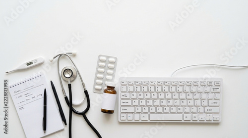 Medical Desk Flat Lay Stethoscope Keyboard Thermometer Pills Notebook Pen on White Background Healthcare Concept