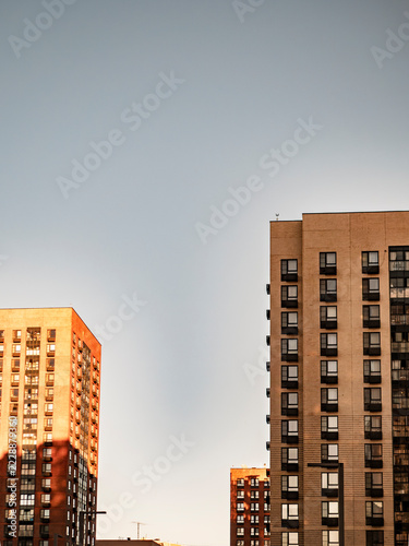 Modern brick residential apartment buildings against clear blue sky at sunset