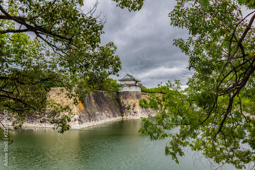 Historic water moat at Osaka Castle Park featuring fortress walls and traditional Japanese architecture, Japan.