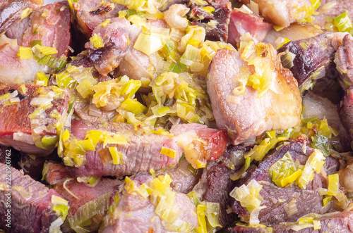Obraz na plátně Close-up of cooked meat chunks with sauteed leeks
