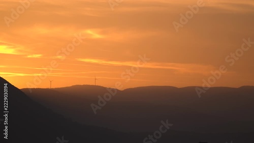 Wind turbines on sunset mountains