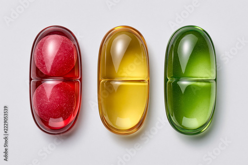 Three colored capsule-shaped objects arranged in a row on a surface