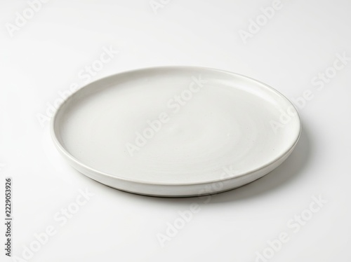 A single, empty, off-white ceramic dinner plate centered on a plain, clean white background.
