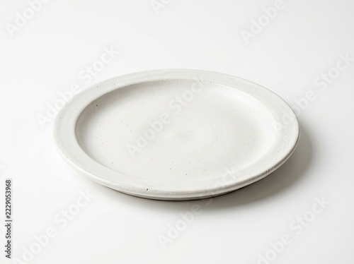 A single empty white ceramic plate with a rustic, speckled texture isolated on a clean white background.