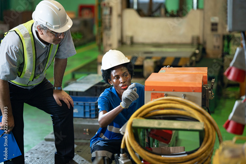 African woman electrician worker with manager engineer man checking, repair, maintaining battery for energy in industry factory