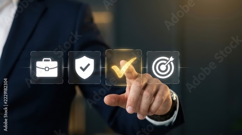 Professional in suit tapping glowing golden checkmark icon on digital interface with briefcase shield and target options representing corporate compliance strategy and success
