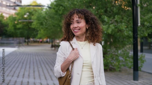 Smiling businesswoman walking outside modern office building