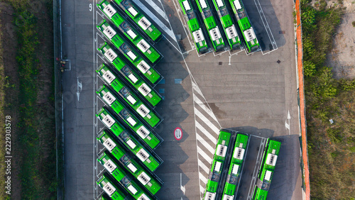 Aerial view of the ATM San Donato bus depot in Milan, showing rows of parked green buses, asphalt parking lanes, and road markings, Milano, Lombardia, Italy.
