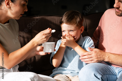 Obraz na plátně Parents encouraging a child refusing food during family mealtime