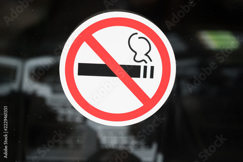 No smoking sign sticker on glass with red circle and cigarette icon