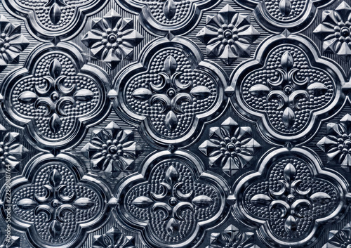 Fotografie Close-up of ornate silver-blue embossed metal tiles with floral quatrefoil patterns
