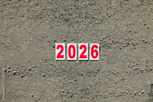 Numbers of 2026 year. Paper square numbers on the grey concrete background, that means coming New Year Eve. Christmas, holidays, celebration concept. New Year of 2026, year of the red fire horse