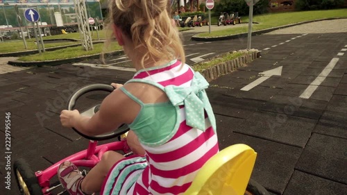 Beautiful little girl rides mechanical go-kart