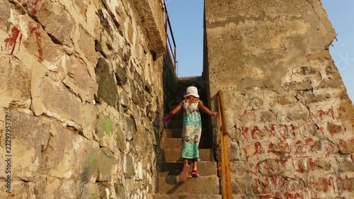 A beautiful girl walks the stairs of a stone lighthouse in the town of Tsarevo on the Black Sea coast in Bulgaria.