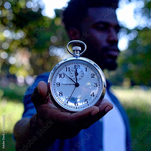 World globe with vintage clock in human hand symbolizing time, global future and urgency to protect the planet