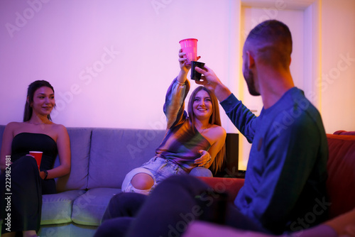 Fotografie Group of friends enjoying a casual gathering while toasting with drinks and enjo