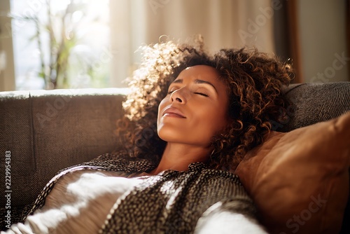 relaxed woman resting on sofa at home with eyes closed. mental wellness, stress relief and self care lifestyle concept