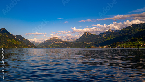 Lake Lucerne view across Canton Schwyz. Lake nature panorama with alpine cloudscape. Brunnen destination beside Lake Lucerne in Switzerland. Swiss summer travel around Lake Lucerne.