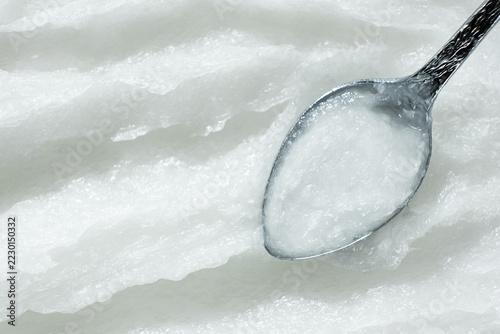 Natural coconut oil on spoon close up with space for text