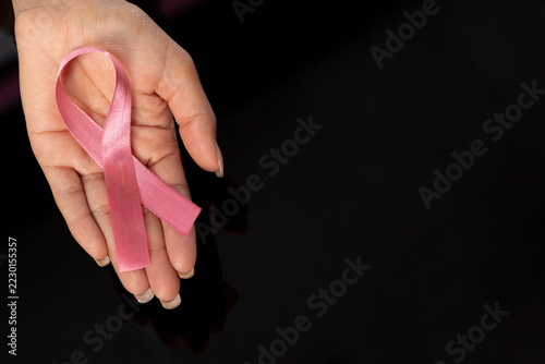 Hand showing pink ribbon for breast cancer awareness