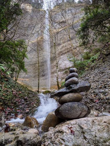 Obraz na plátně Stacked Stones Beside A Stream Below La Pisserotte Waterfall
