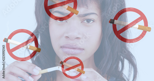 Image of lit cigarettes with no smoking signs over woman breaking cigarette