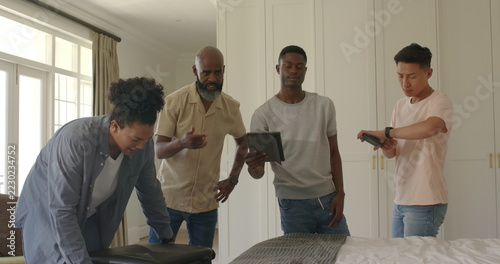 Packing suitcase, diverse group of friends preparing for wedding trip together