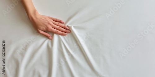 Hand Pulling White Bedsheet Fabric