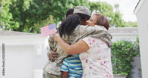 Image of african american family welcoming soldier mother after returning home