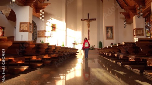 ZAKOPANE, POLAND - NOVEMBER 8 2018: Girl in a red jacket walking inside the Holy Cross Church in Zakopane.