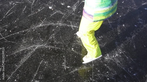 Slow motion. Girl skating on ice frozen lake.