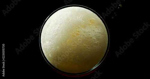 High angle view of beer poured in glass against black background