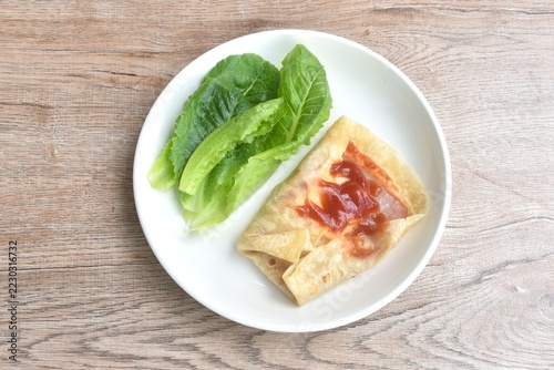 berrito stuffed slice ham pork with cheese dressing ketchup sauce eat couple fresh cos lettuce vegetable salac on plate