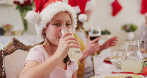 Caucasian girl in santa hat drinking juice