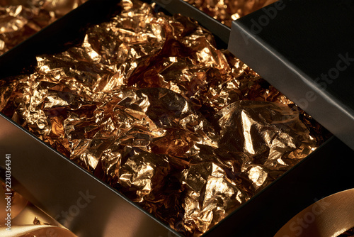 Open Black Gift Box with Gold Tissue Paper, Luxury Unboxing Concept