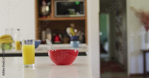 Close up of red bowl and glass of juice on countertop in kitchen