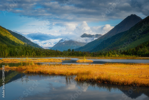 Fotografie Golden wetland marsh with ponds reflecting mountains in an Alaska valley