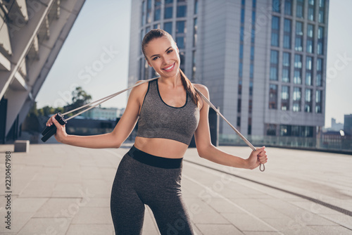 Photo of sportive positive energetic lady hold jumping rope ready intense aerobics agility exercise outside gym