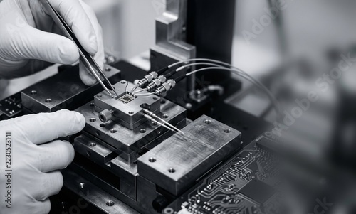Close up of engineer hands adjusting a silicon photonics optical transceiver in a high speed test rig for telecommunication network data center infrastructure