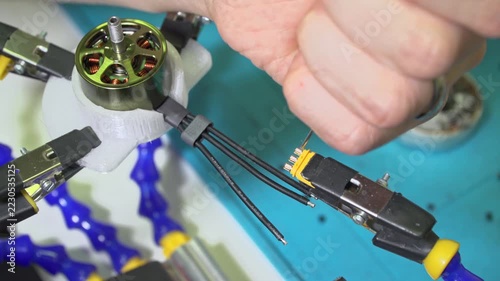 FPV drone assembly Trimming motor wires with scalpel knife. precise handcraft, wire insulation trimming, and electronics repair