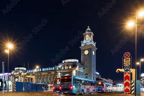 Kyiv railway station and electric buses at night in city transit hub. Ukrainian capital public transportation and rail travel. Urban infrastructure, commuter mobility and sustainable