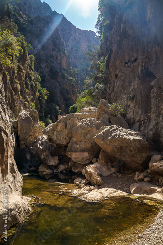 Hiker exploring the towering limestone gorge of Torrent de Pareis in Mallorca, Spain