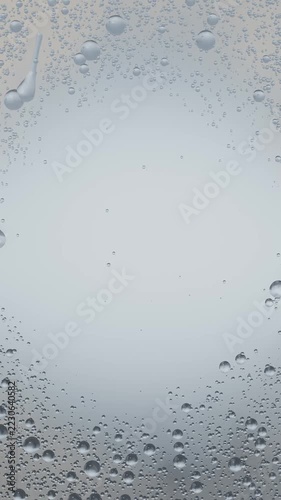 Vertical video: Drizzle starting, water droplets merging and sliding into streaks on window glass