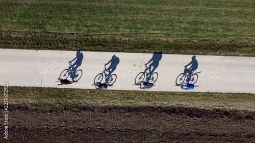Cyclists, bicycles, shadows, riding on a path, Subotica, Serbia. g2.